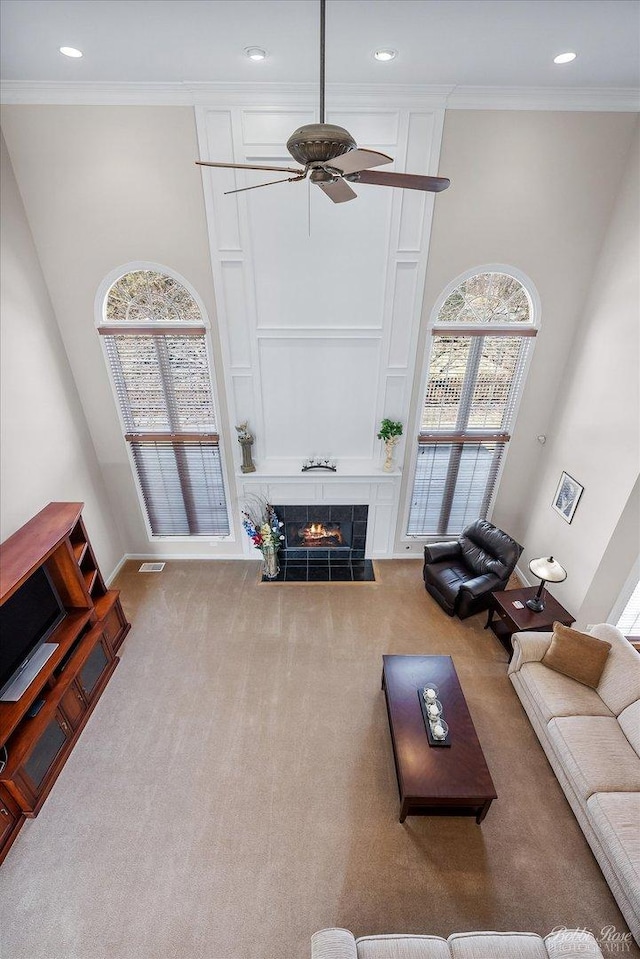 living area featuring a wealth of natural light, crown molding, and carpet floors