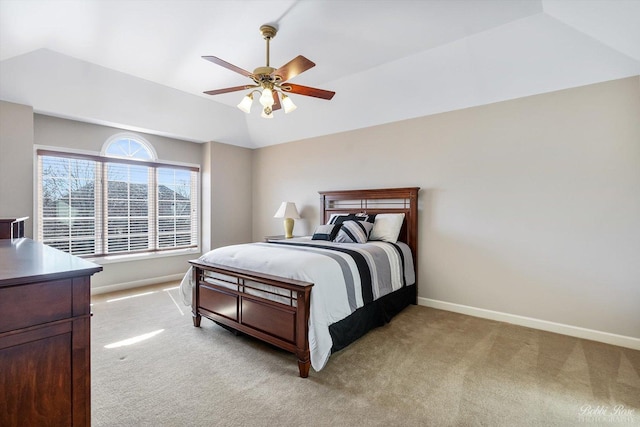 bedroom featuring baseboards, light colored carpet, a ceiling fan, and vaulted ceiling