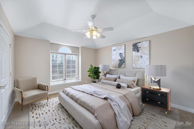 bedroom with a ceiling fan, a raised ceiling, light colored carpet, and baseboards