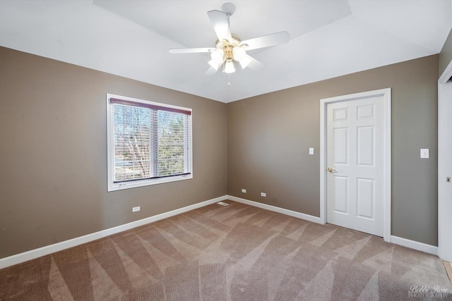 empty room with baseboards, a ceiling fan, and carpet