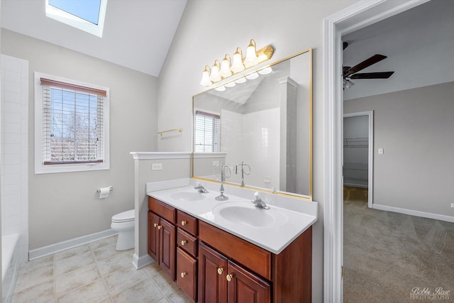 bathroom with lofted ceiling with skylight, double vanity, a sink, a shower, and ceiling fan