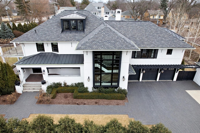 modern inspired farmhouse featuring a chimney, stucco siding, metal roof, and a standing seam roof