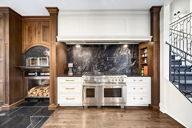 kitchen featuring double oven range, decorative backsplash, dark wood-type flooring, white cabinetry, and dark countertops