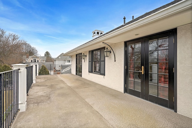 view of patio with french doors and fence