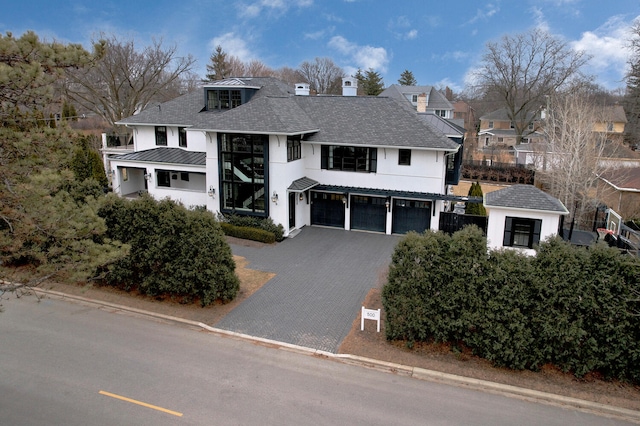 view of front of home with decorative driveway, metal roof, an attached garage, and a standing seam roof