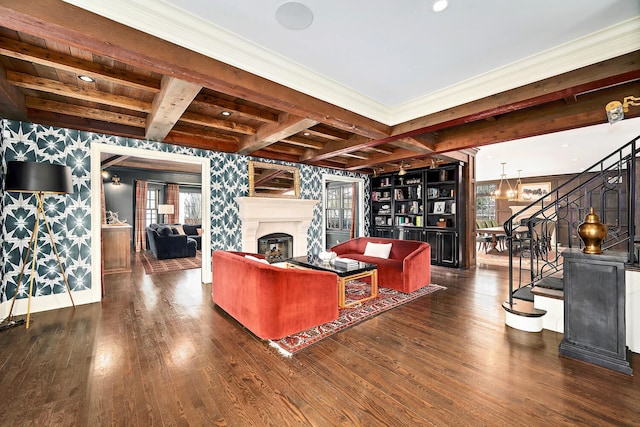 living area featuring stairway, wood finished floors, wallpapered walls, a fireplace, and beamed ceiling