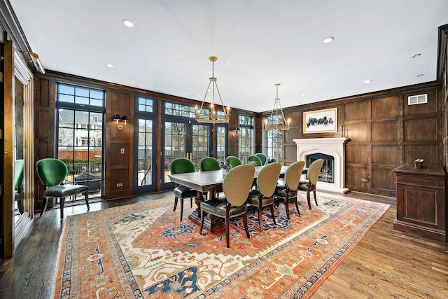 dining area with visible vents, a notable chandelier, wood finished floors, and crown molding