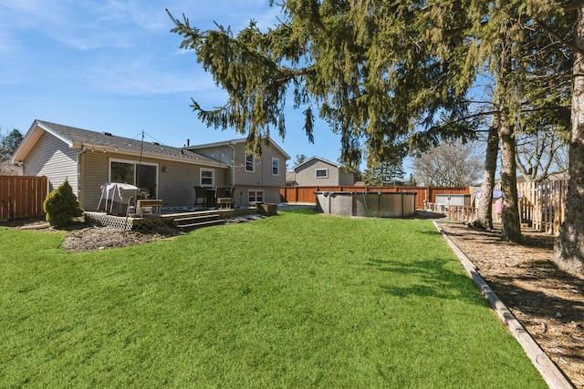 view of yard featuring a deck, a fenced in pool, and a fenced backyard