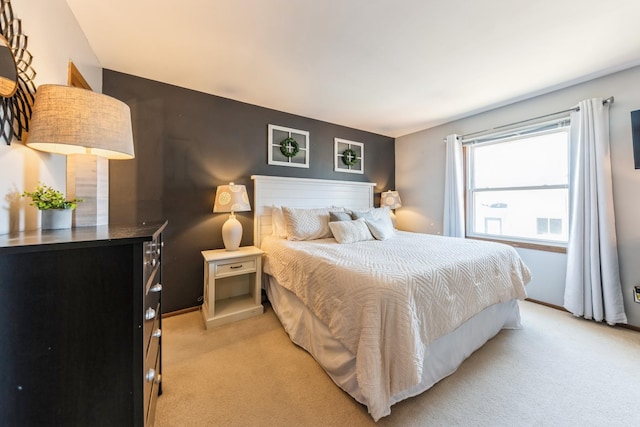 bedroom with baseboards and light colored carpet