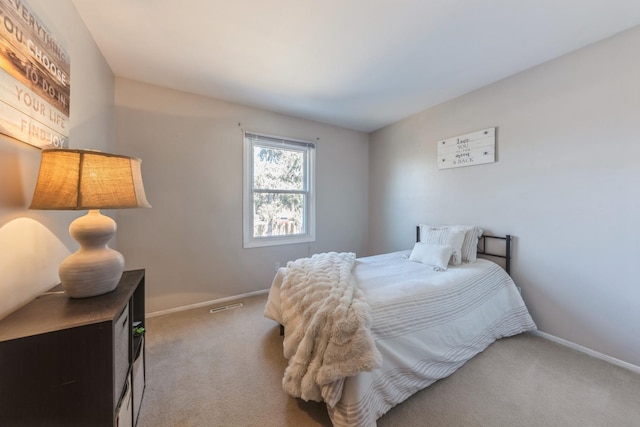 carpeted bedroom featuring visible vents and baseboards