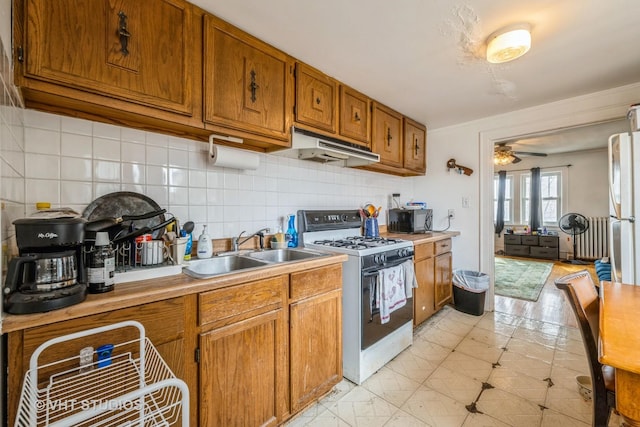 kitchen featuring white gas stove, ceiling fan, a sink, black microwave, and under cabinet range hood