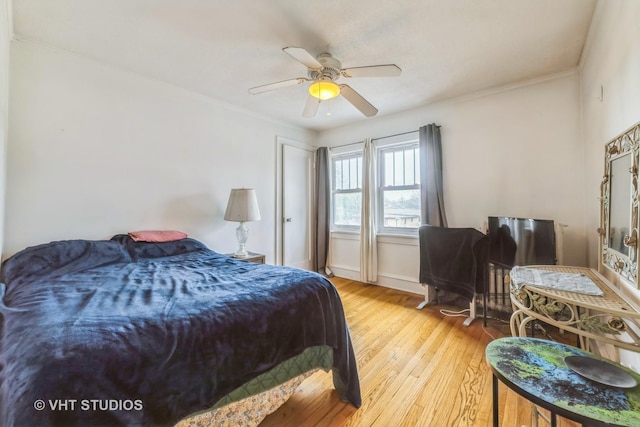 bedroom with baseboards, crown molding, a ceiling fan, and wood finished floors