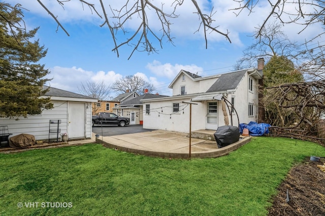 rear view of house featuring a patio, fence, a yard, stucco siding, and a chimney