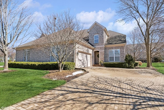 traditional-style house with an attached garage, a front yard, decorative driveway, and brick siding