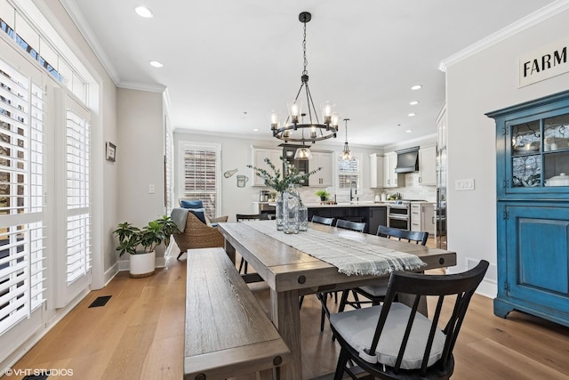 dining space featuring light wood-style flooring, baseboards, crown molding, and recessed lighting