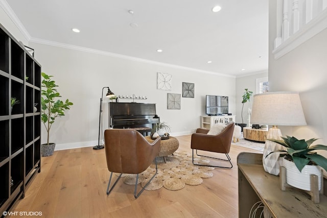 living area featuring light wood-style flooring, baseboards, and crown molding