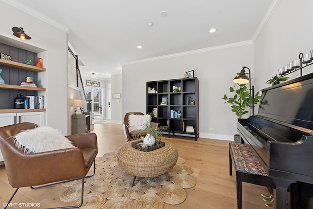 living area with light wood-style flooring, ornamental molding, baseboards, and a barn door