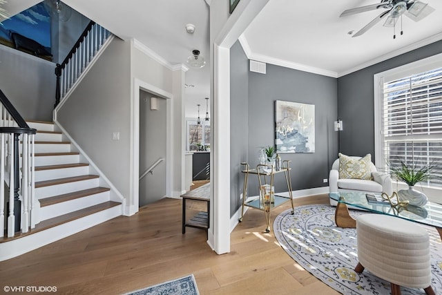 sitting room featuring crown molding, visible vents, stairway, wood finished floors, and baseboards