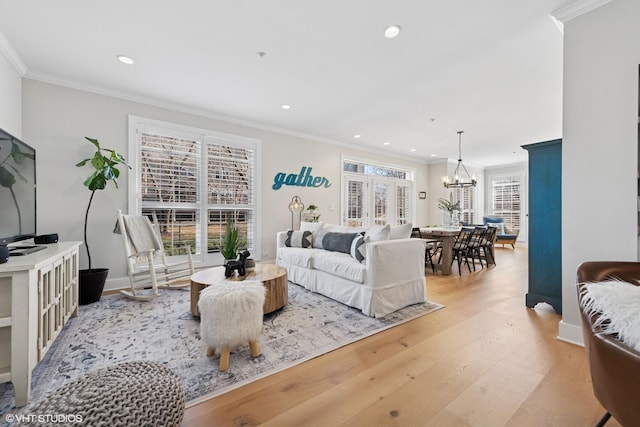 living room featuring a wealth of natural light, light wood-style flooring, and crown molding