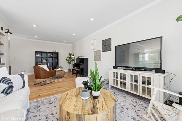 living room featuring baseboards, recessed lighting, wood finished floors, and crown molding