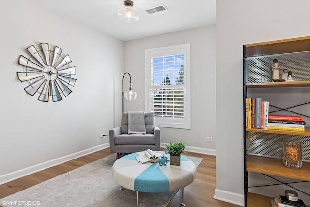 sitting room featuring visible vents, baseboards, and wood finished floors