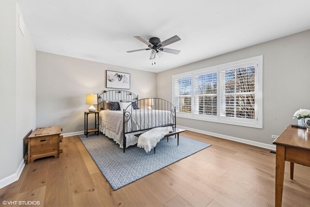 bedroom with wood-type flooring, ceiling fan, and baseboards