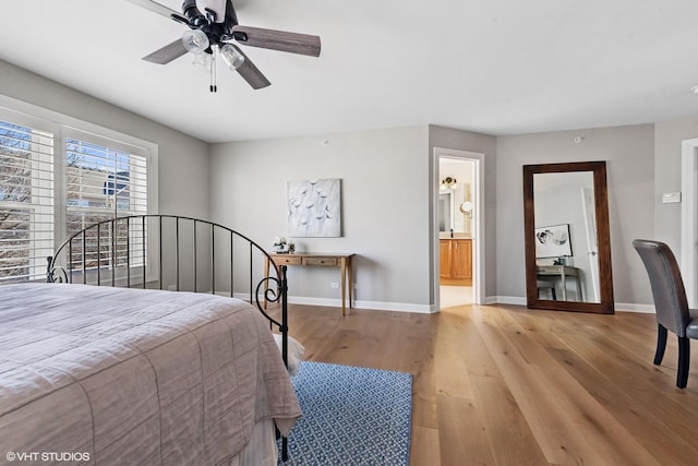 bedroom with a ceiling fan, connected bathroom, baseboards, and wood finished floors