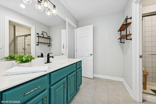 full bath featuring baseboards, a stall shower, vanity, and tile patterned floors