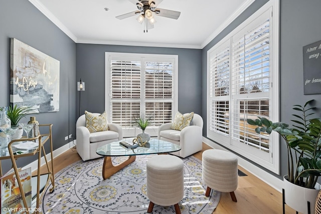 sitting room with a healthy amount of sunlight, crown molding, and wood finished floors