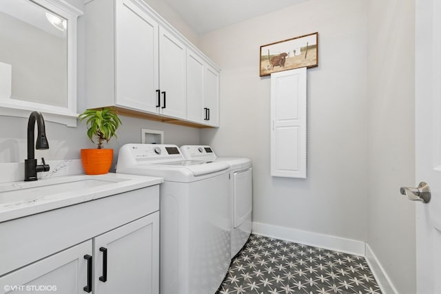 laundry room featuring cabinet space, baseboards, tile patterned floors, separate washer and dryer, and a sink