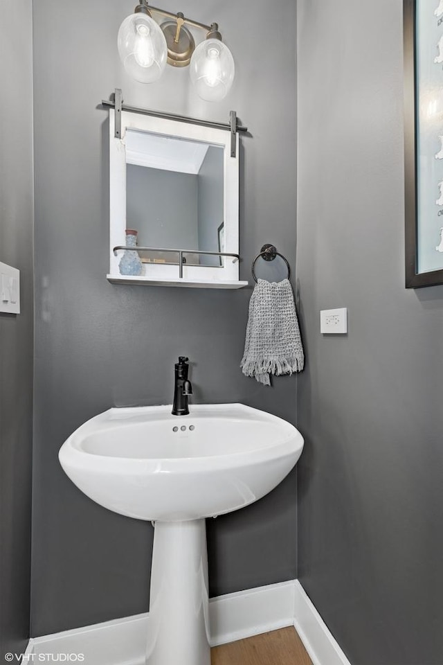 bathroom with baseboards, a sink, and wood finished floors