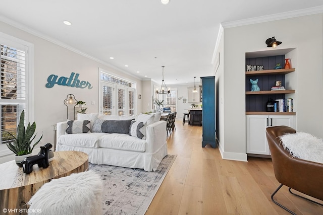 living area featuring a chandelier, recessed lighting, crown molding, and light wood-style flooring