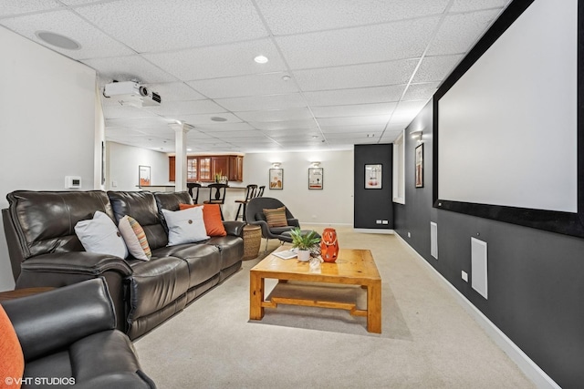 cinema room with carpet floors, a drop ceiling, and baseboards