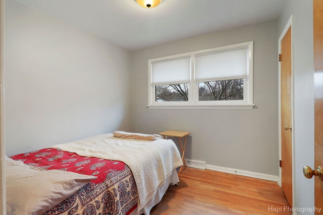 bedroom with baseboards and wood finished floors