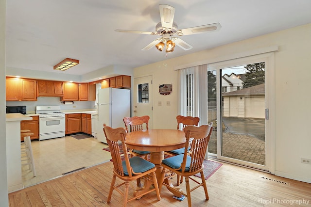 dining area featuring visible vents, light wood-style flooring, and a ceiling fan