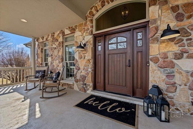 property entrance featuring stone siding and covered porch