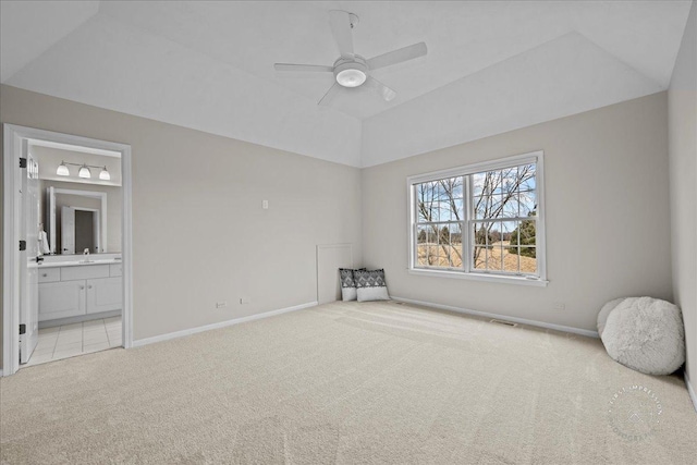 unfurnished bedroom with light carpet, vaulted ceiling, visible vents, and baseboards