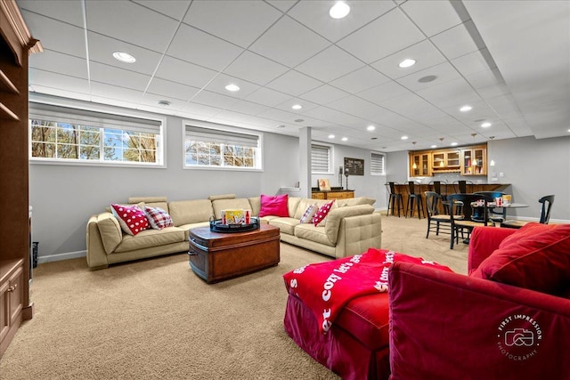 carpeted living area featuring recessed lighting, a drop ceiling, plenty of natural light, and baseboards