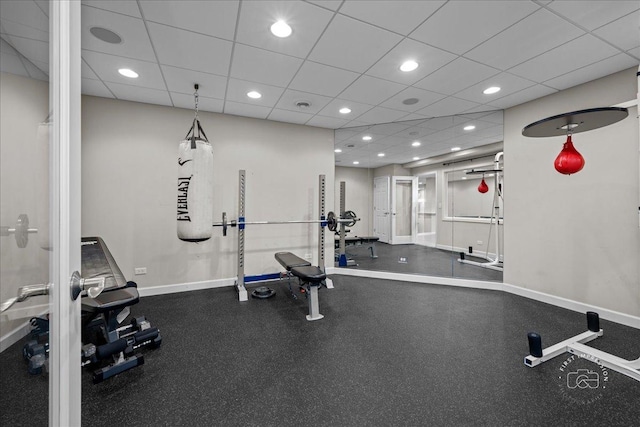 workout room featuring baseboards, a drop ceiling, and recessed lighting