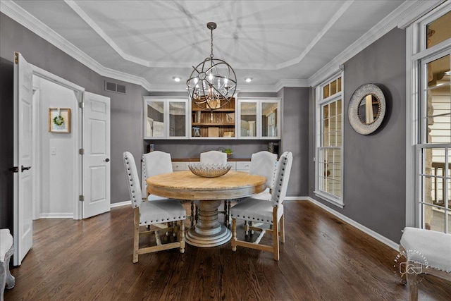 dining space featuring baseboards, visible vents, a tray ceiling, and dark wood-style flooring