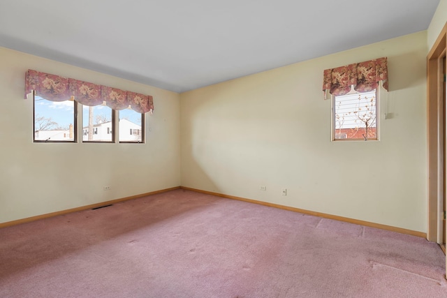 unfurnished room featuring baseboards, visible vents, and light colored carpet