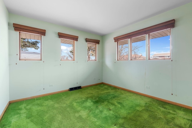 spare room with carpet, visible vents, and baseboards