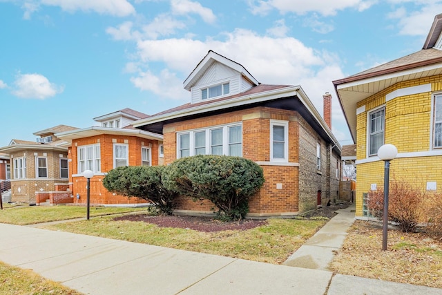 bungalow with brick siding and a front yard