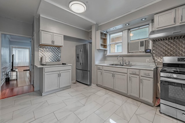 kitchen with tasteful backsplash, light countertops, appliances with stainless steel finishes, a sink, and under cabinet range hood