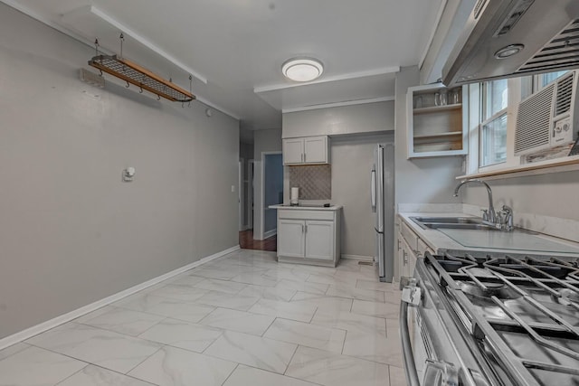 kitchen with under cabinet range hood, a sink, marble finish floor, light countertops, and gas stove