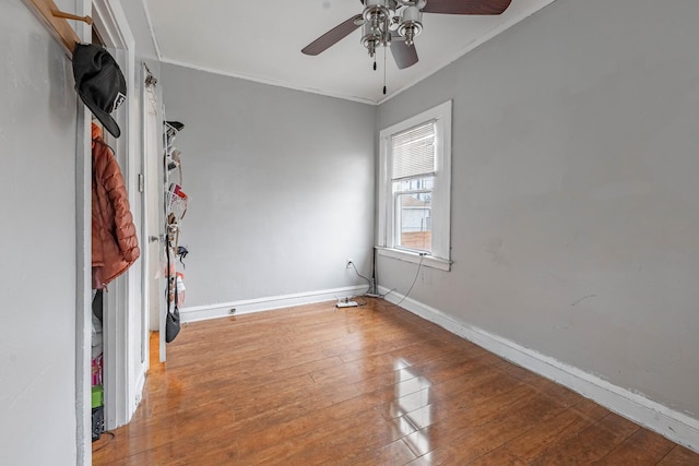 spare room with ornamental molding, baseboards, ceiling fan, and hardwood / wood-style floors