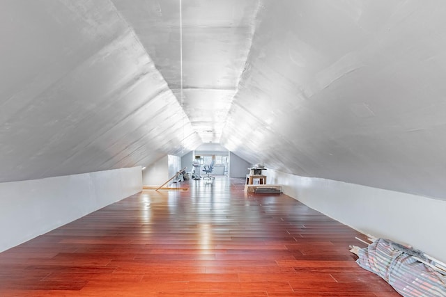 additional living space featuring hardwood / wood-style flooring and vaulted ceiling