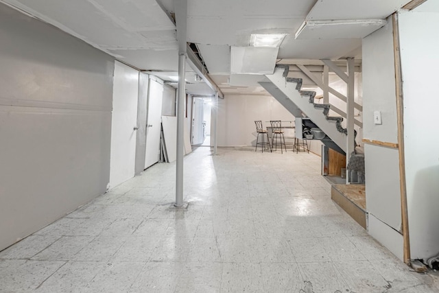 finished basement with tile patterned floors and stairs