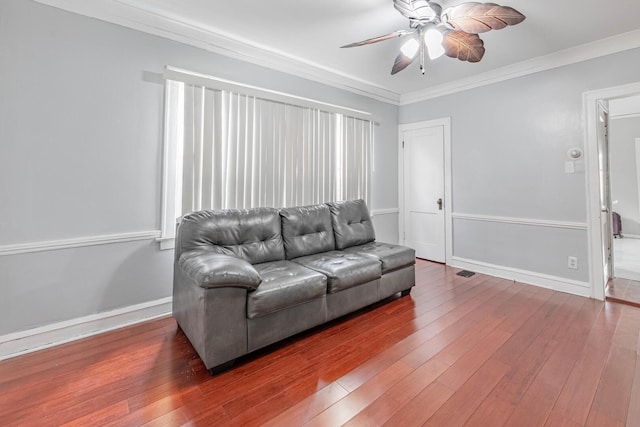 living area with ceiling fan, ornamental molding, hardwood / wood-style flooring, and baseboards