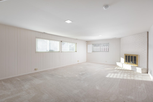 unfurnished living room with a fireplace, baseboards, and carpet floors